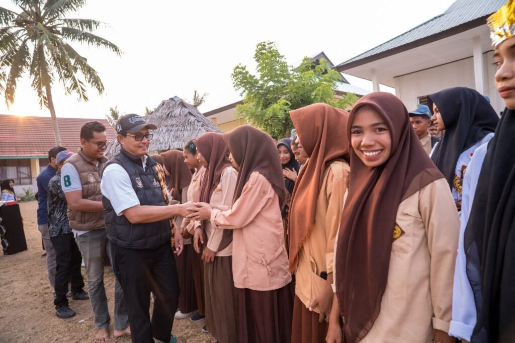 Para siswi menyambut rombongan dengan berjabat tangan di halaman sekolah dalam kunjungan ke sekolah di Maluku Utara.